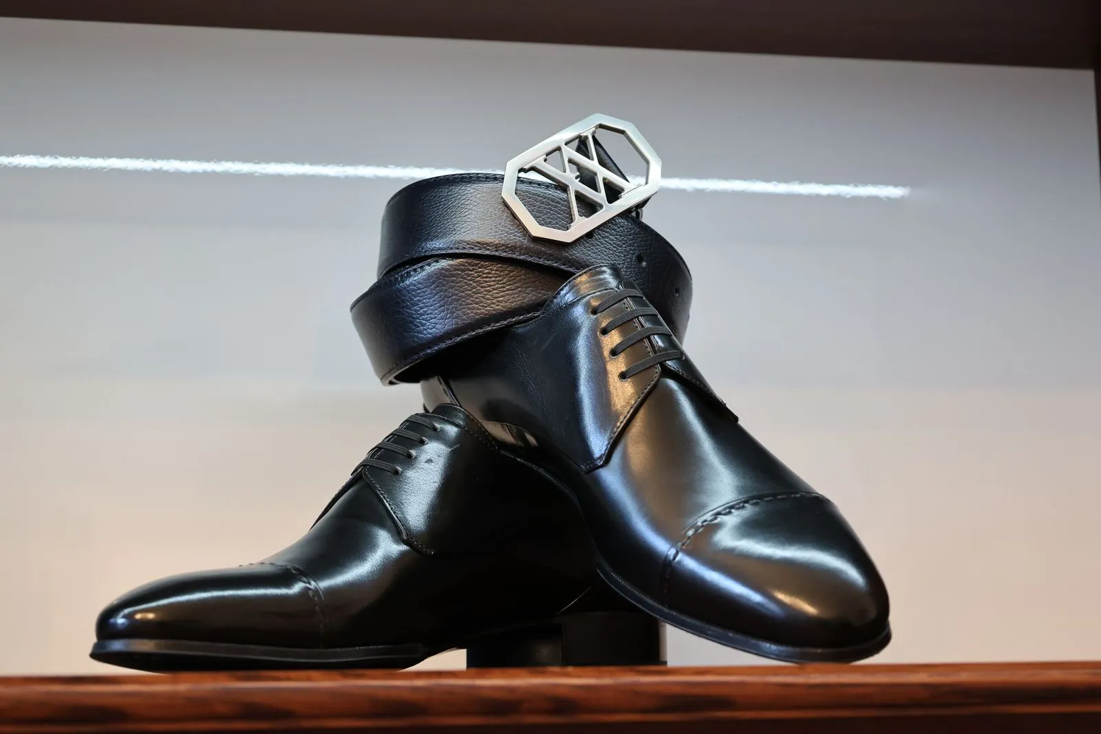 Classic black leather shoes paired with a matching belt in a stylish arrangement.